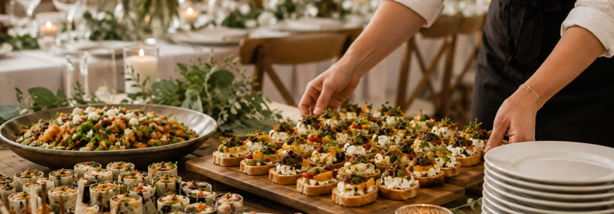 Caterer arranging canapés and buffet dishes before an event